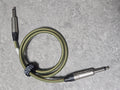 Braided audio cable with metal connectors on a gray surface