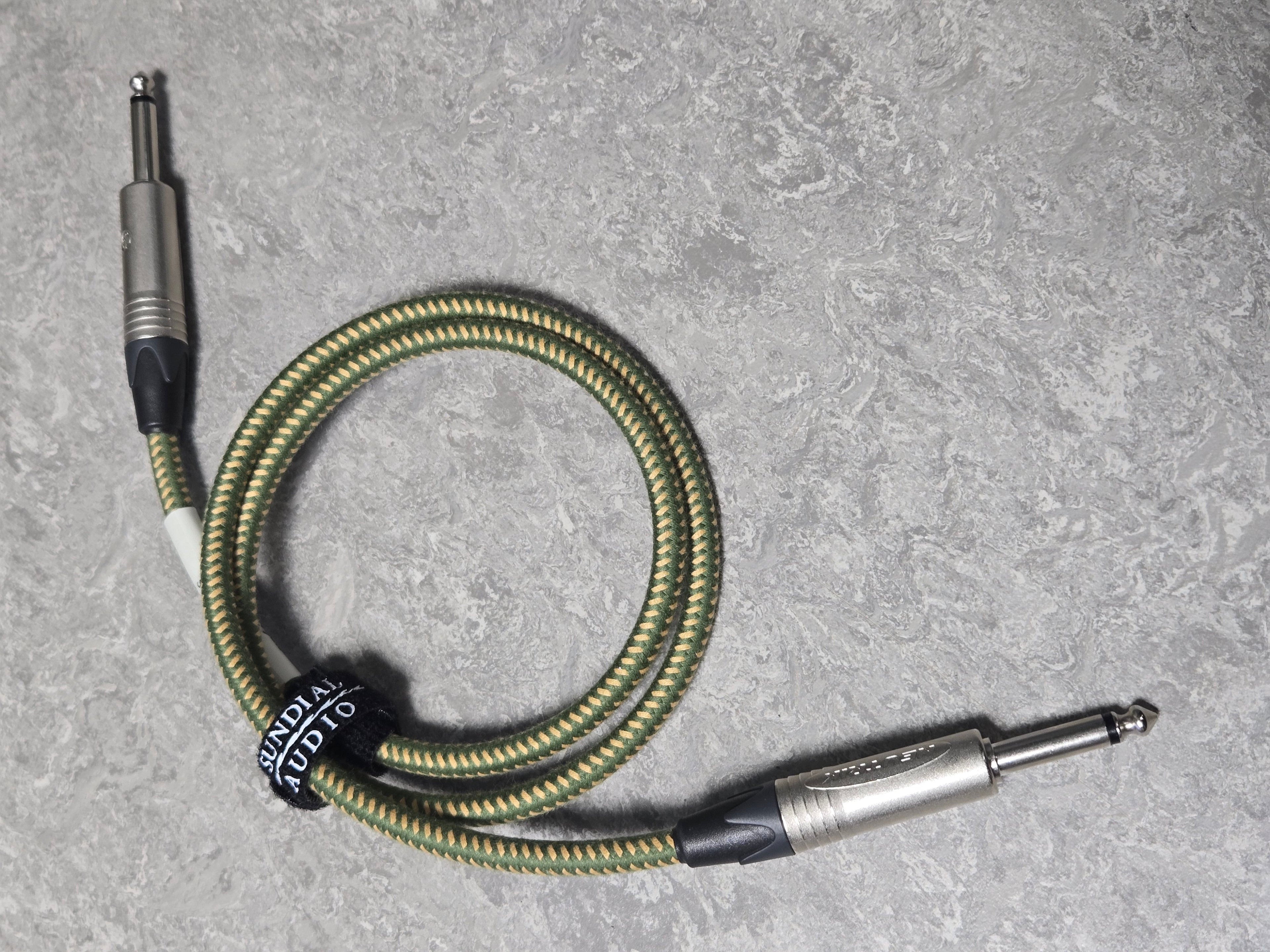 Braided audio cable with metal connectors on a gray surface