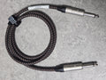 Braided audio cable with metal connectors on a gray surface