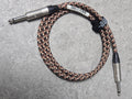 Braided audio cable with connectors on a gray surface
