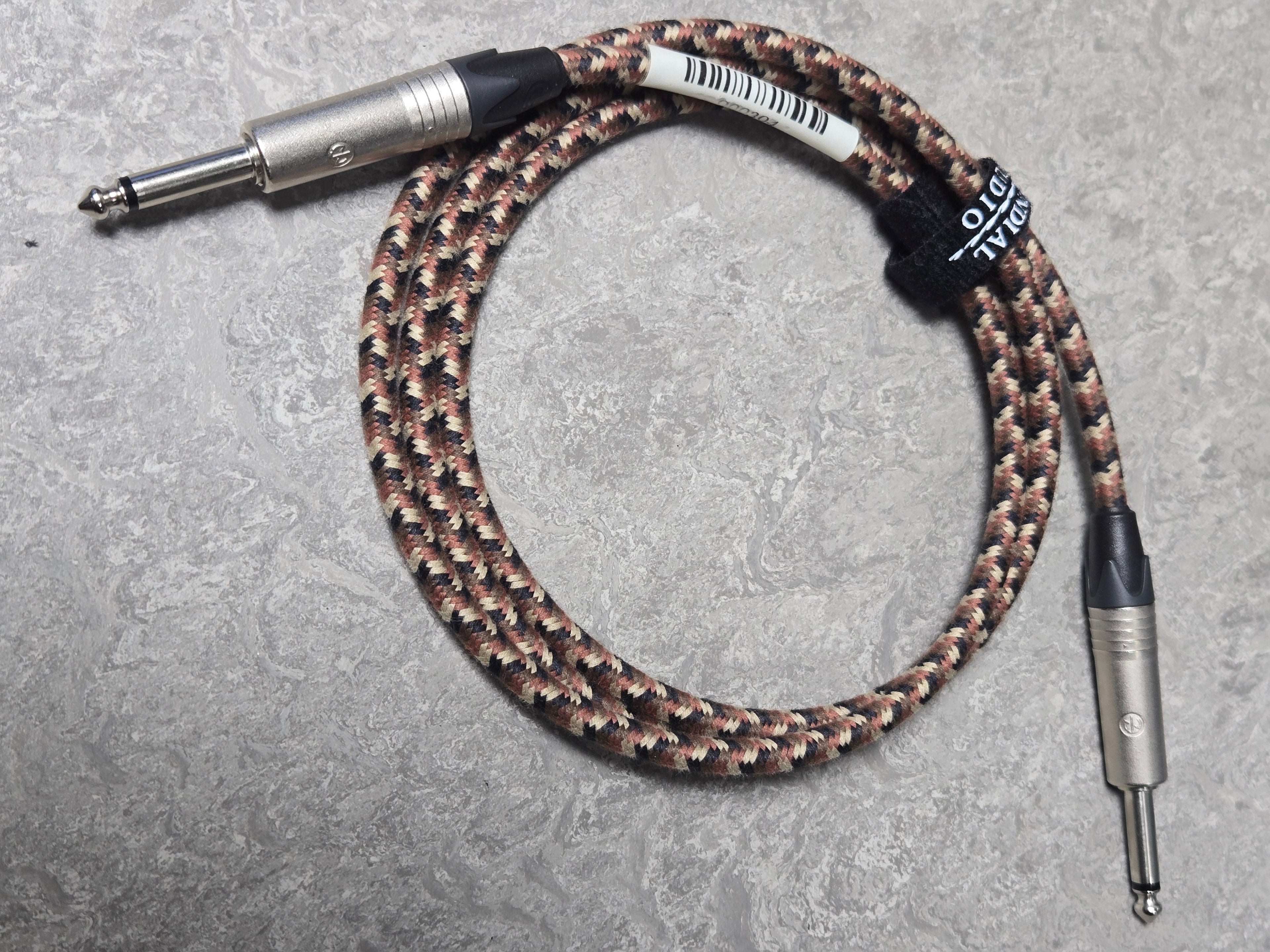 Braided audio cable with connectors on a gray surface